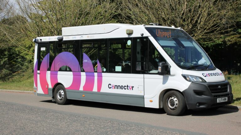 Fusion Processing launches Cambridge’s first automated bus service Fusion Processing launches Cambridge’s First automated bus service. The xxx bus is shown here on a a UK road, with green trees on the verge.