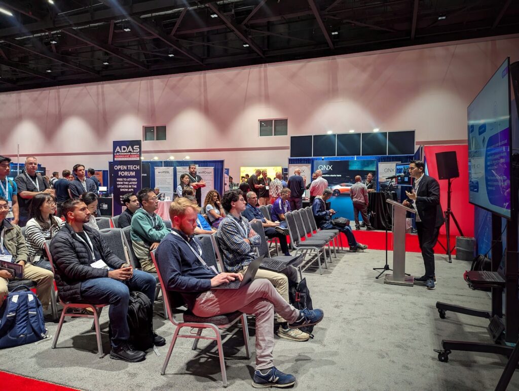 The Open Tech Forum at ADAS & Autonomous Vehicle Technology Summit North America 2025, with attendees sat in chairs listening to a presentation