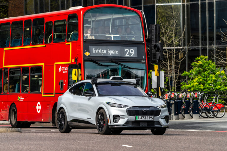 Wayve secures US$1.5bn to scale commercial deployment of its embodied AI autonomy platform A Wayve-powered autonomous car drives on a London road alongside a red bus.