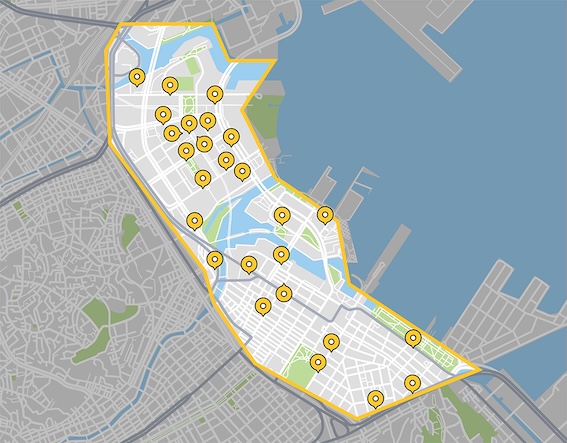 A city map showing a highlighted area outlined in yellow, containing multiple yellow markers with black dots at their centers. The map includes geographical features such as roads, waterways, and green spaces. A waterfront or harbor area is visible on the right side. No landmark names are shown, making the map suitable for location analysis or navigation purposes.