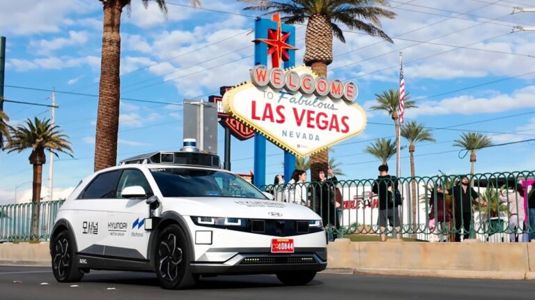 Hyundai Ioniq 5 robotaxi in front of a las vegas sign