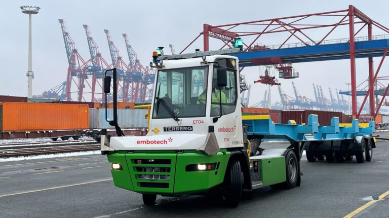 An Embotech autonomous terminal tractor (ATT), in white and green, in operation at Eurogate's Hamburg terminal in Germany.