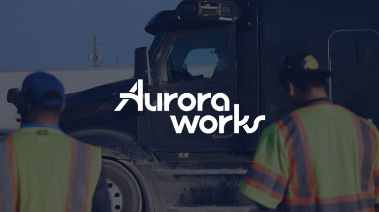 Aurora Works logo in white on top of an image of workers in high-vis jackets in front of a freight truck.