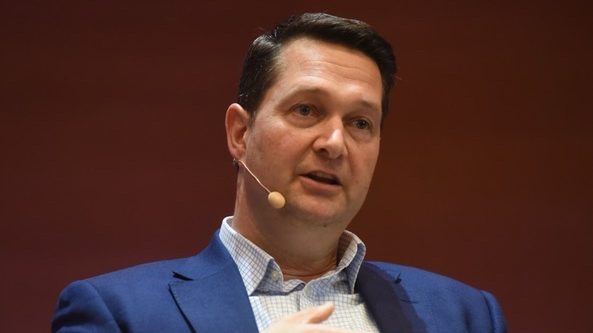 Headshot of INTERVIEW: Lukas Neckermann, board member, PAVE Europe, wearing a dark blue suit and light blue shirt and a clip-on microphone.