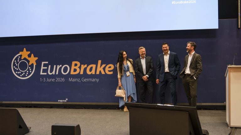 representatives of FISITA and Vehicle Tech Week stand on a stage in front of a large screen displaying the EuroBrake 2026 logo.