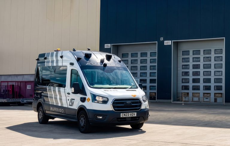 Aurrigo International awarded £1.43m UK government funding to boost airport safety An Aurrigo SENTRY autonomous vehicle parked outside a warehouse or industrial facility.